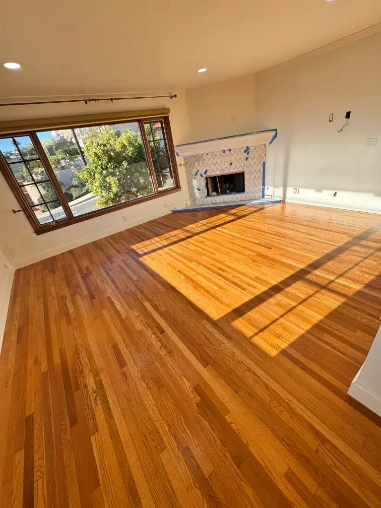 Sunlit living room with freshly refinished red oak hardwood floors